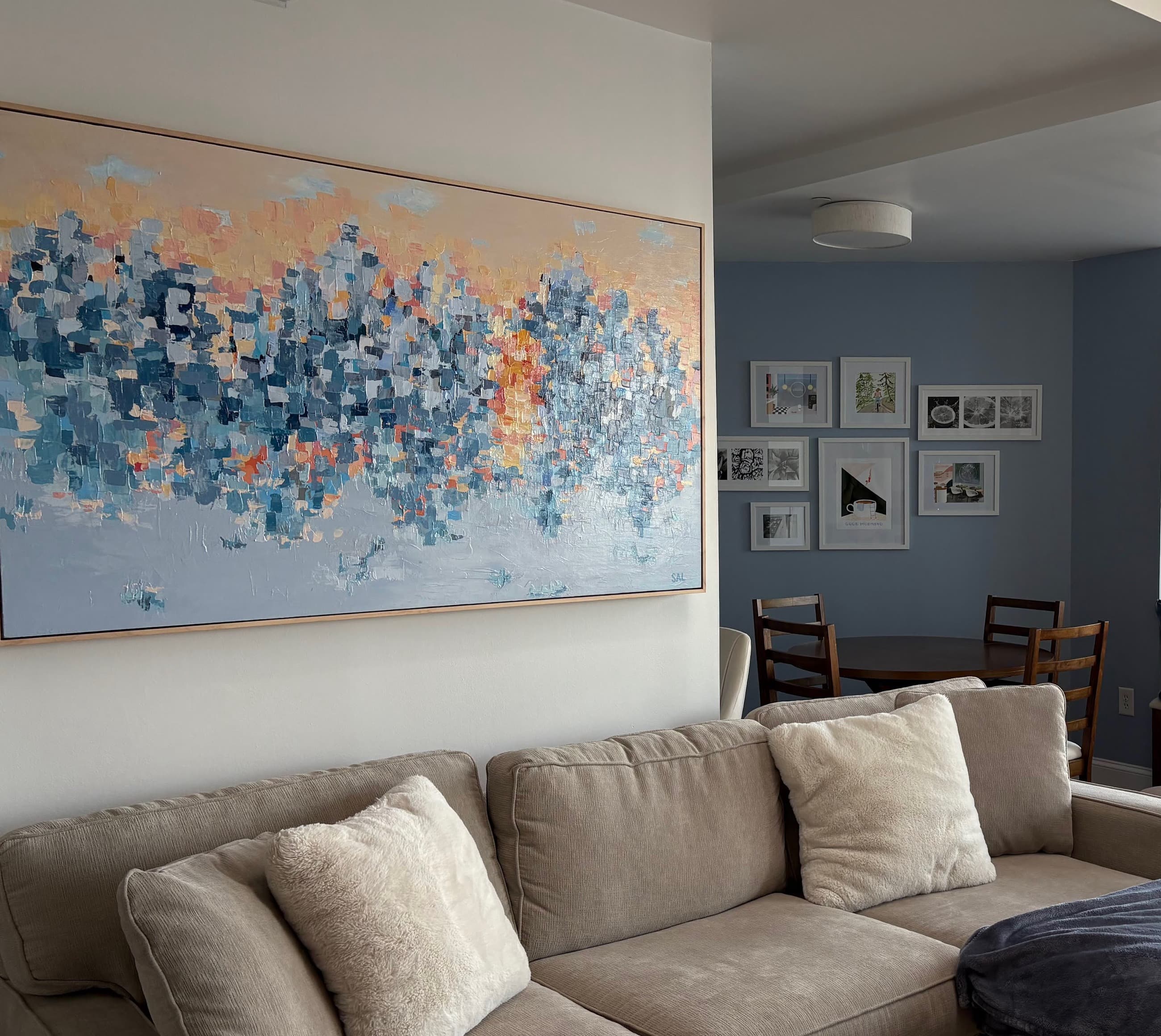 Abstract cityscape painting in blues and warm sunset tones