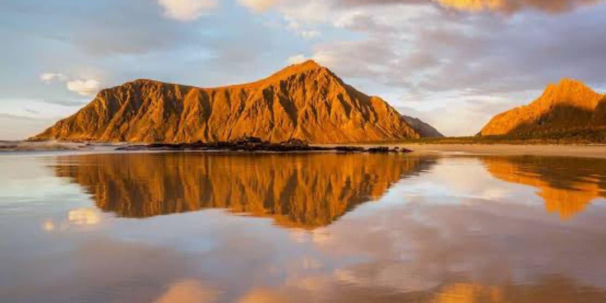 Mountain landscape reflected in still water at sunset, symbolizing clarity and reflection